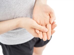 突き指で痛みのある指を押さえる様子