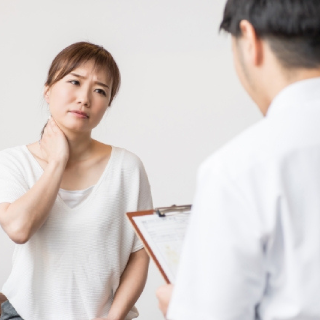 交通事故でむち打ちになり首を押さえている人物の写真