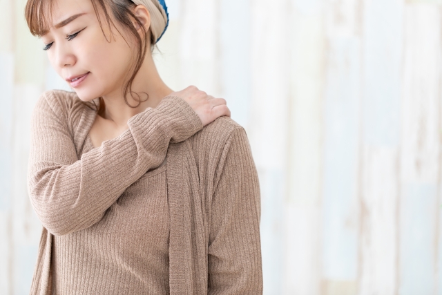 季節の変わり目に肩こりを感じている女性